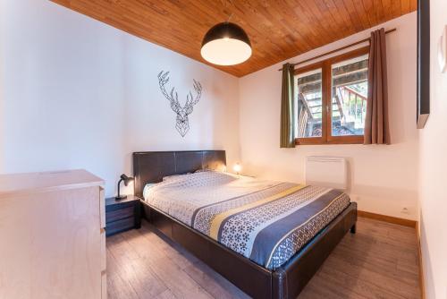 een slaapkamer met een bed en een raam bij Le Petit Lieu Les Orres Appartement Charmant in Les Orres