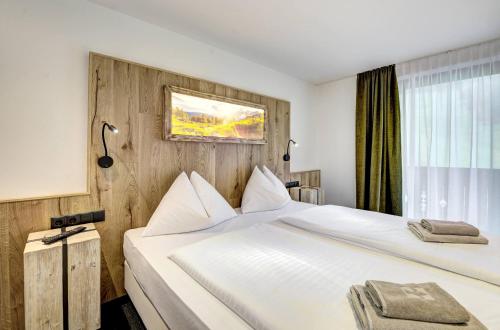 a hotel room with two beds and a window at Auszeit Filzmoos in Filzmoos