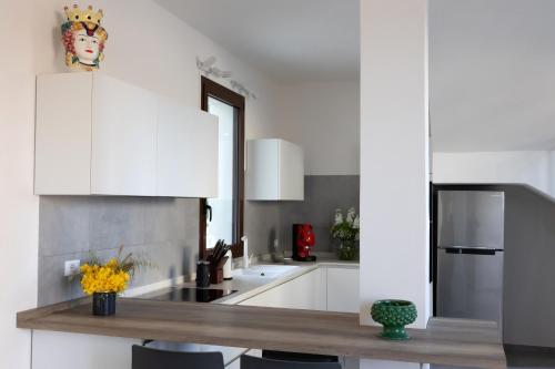 a kitchen with white cabinets and a wooden counter top at Casa B, Room 5 - mit Pool - at Lagoon - Lo Stagnone Kite Spot - Palm Kite Paradise in Marsala