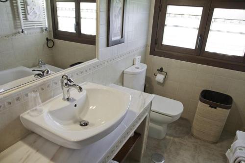 Apartamentos Hacienda Llamabua في نافيا: حمام مع حوض ومرحاض ومرآة