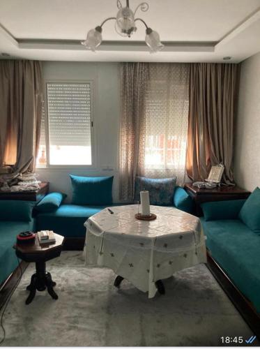 Sala de estar con sofás azules y mesa de centro en Ala din, en Bel Aroussi