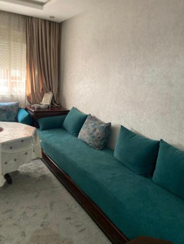 sala de estar con sofá verde y mesa en Ala din, en Bel Aroussi