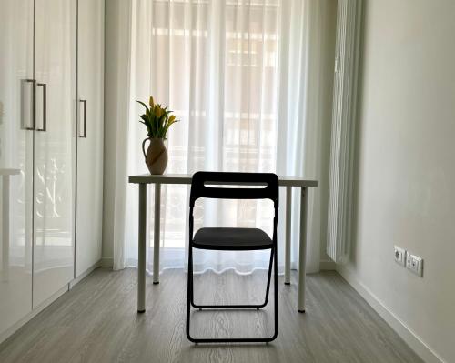 einem Stuhl, der an einem Tisch vor einem Fenster sitzt in der Unterkunft Domus Fersina in Trient