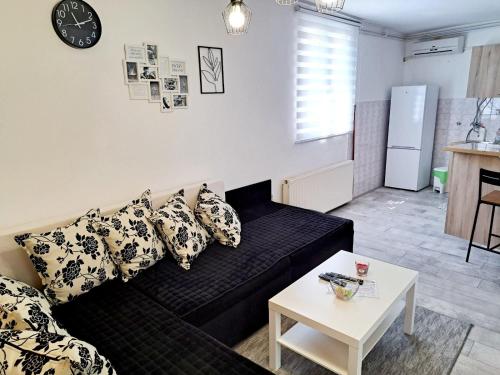 a living room with a black couch and a table at Stefan Apartman in Novi Sad