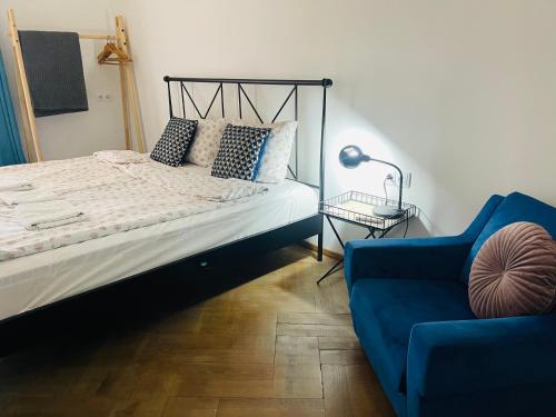 Guest House Third Floor في تبليسي: غرفة نوم بسرير واريكة زرقاء