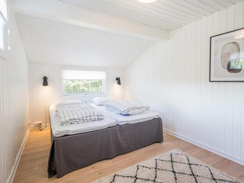 a white room with a bed and a window at Holiday home Nørre Nebel LXXXIV in Nørre Nebel