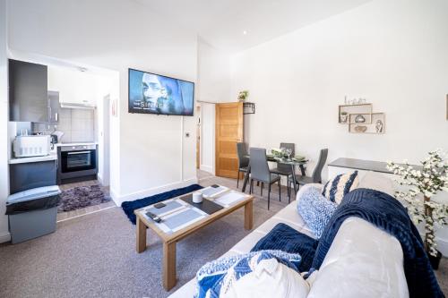 巴恩斯利的住宿－Cozy 1-Bedroom Apartment in the Heart of Barnsley Town Centre，客厅配有沙发和桌子