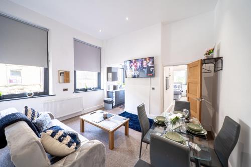uma sala de estar com um sofá e uma mesa em Cozy 1-Bedroom Apartment in the Heart of Barnsley Town Centre em Barnsley