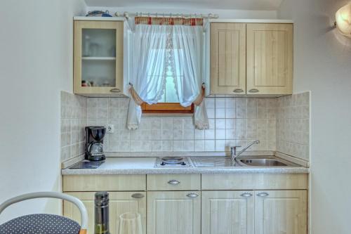 a small kitchen with a sink and a window at Apartmets Slavica 1644 in Banjole
