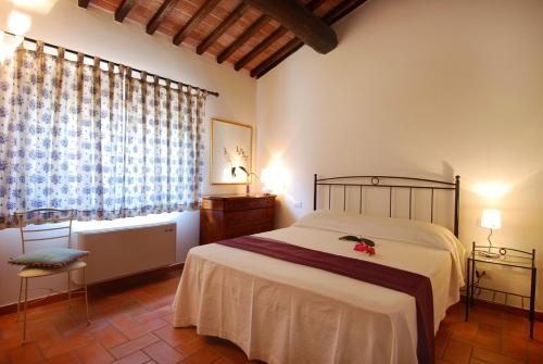 Un dormitorio con una cama grande y una ventana en Agriturismo Raccianello, en San Gimignano