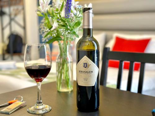 a bottle of wine and a glass on a table at Paamonim Hotel Jerusalem in Jerusalem