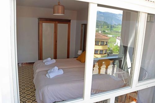 Zimmer mit 2 Betten und einem Fenster in der Unterkunft La Cerona N°1 in Colunga