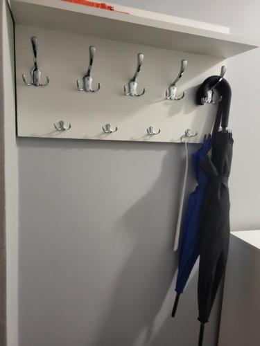 a shelf with two umbrellas hanging on a wall at Apartament Ares in Mieroszów