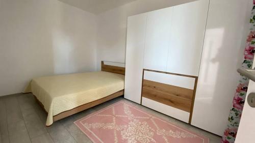 Dormitorio pequeño con cama y alfombra rosa en Lola seaview guest house. Уютный Домик в Варне en Varna