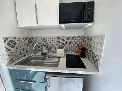 a kitchen counter with a sink and a microwave at Le Bonheur 1827 in Marseille