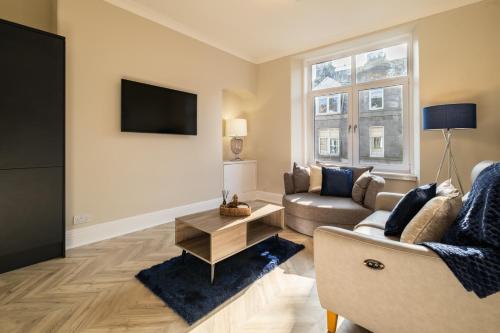 uma sala de estar com um sofá e uma televisão em Modern City Stay - SJA Stays - 2 Bed Apartment em Aberdeen