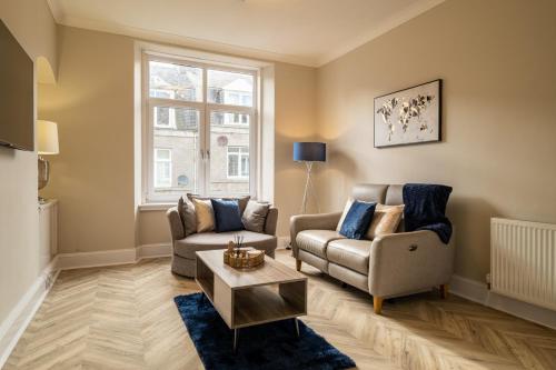 uma sala de estar com dois sofás e uma mesa em Modern City Stay - SJA Stays - 2 Bed Apartment em Aberdeen