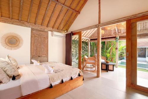 a bedroom with a bed and a large window at Villa Balimasan 10 mins to Canggu in Seminyak