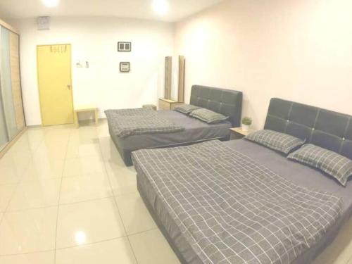 two beds in a large room with at Arang Homestay14pax 4room(BBQ)(Kbox)Near to Beach in Port Dickson