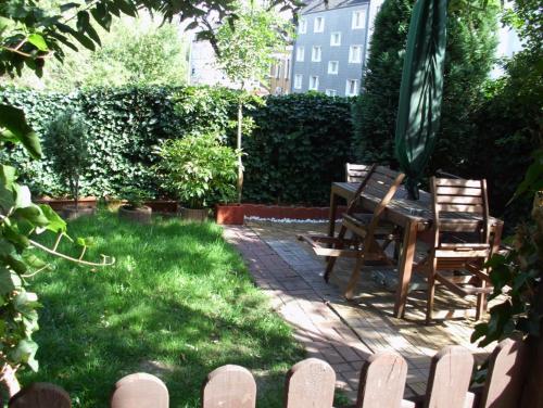 een patio met stoelen, een tafel en een parasol bij Schönes Zimmer im Seterant/Untergeschoss in Essen