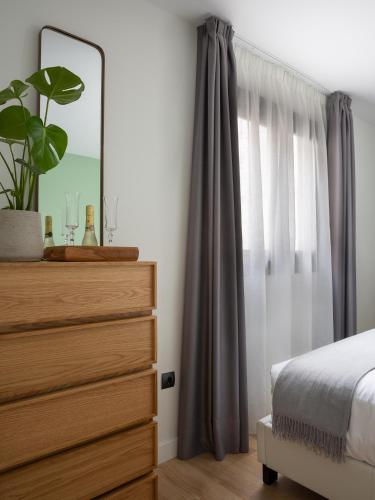 a bedroom with a bed and a dresser with a mirror at Flipco Málaga in Málaga