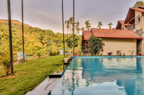 a swimming pool in front of a house at Hill Crest Resort - Coorg in Madikeri