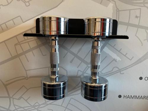 a metal bar stool with two metal cups on a shelf at ProfilHotels Nacka in Stockholm
