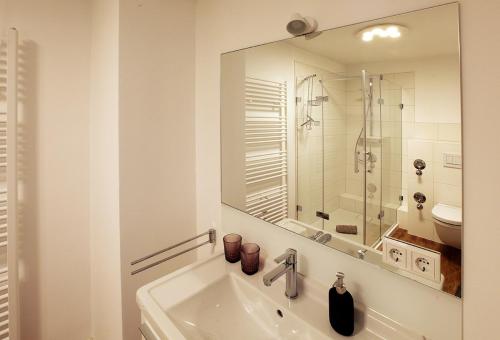 een witte badkamer met een wastafel en een spiegel bij Weingut Schäffer in Neustadt an der Weinstraße
