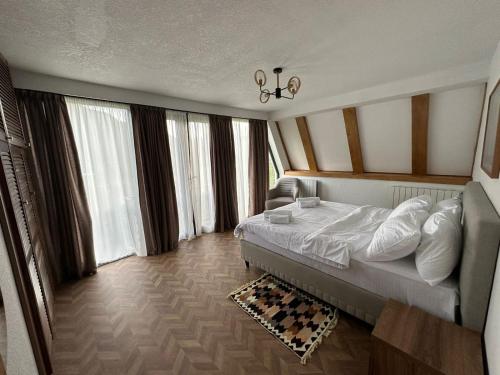 a hotel room with a bed and large windows at Karse in Ambrolauri