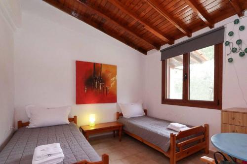 a bedroom with two beds and a table and window at Docker 2 Beachfront Villa Vourvourou by Halkidiki Villas in Vourvourou