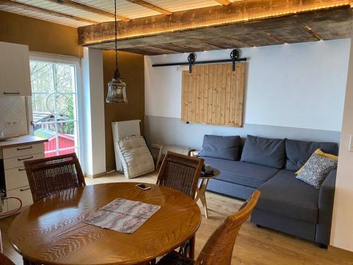 a living room with a table and a blue couch at Ferienwohnung Hückeswagen (Bevertalsperre) in Hückeswagen