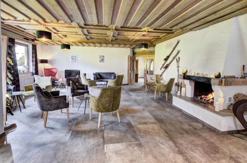 a living room with a fireplace and chairs at Auszeit Filzmoos in Filzmoos