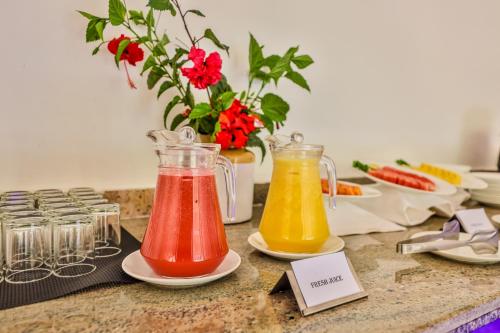 a table with two vases of different colored liquids at Hill Crest Resort - Coorg in Madikeri