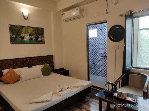 a bedroom with a bed and a shower in a room at Max Guest House in Agra