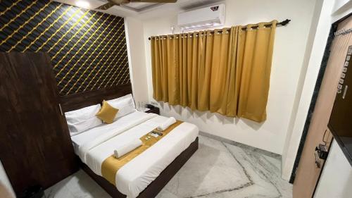 um quarto com uma cama com uma cortina amarela em Hotel Plaza Rooms - Prabhadevi Dadar em Mumbai