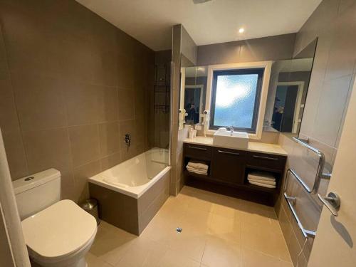 bagno con lavandino, servizi igienici e finestra. di IceBreaker - Mount Hotham a Mount Hotham