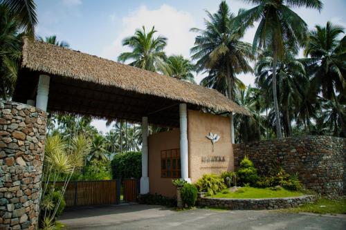 ein kleines Gebäude mit Palmen im Hintergrund in der Unterkunft Maayaa riverside villa by KPM Tripenta in Attappādi
