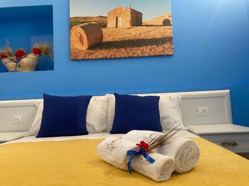 a bedroom with a bed with a painting on the wall at La Bifora e il granaio in Sciacca