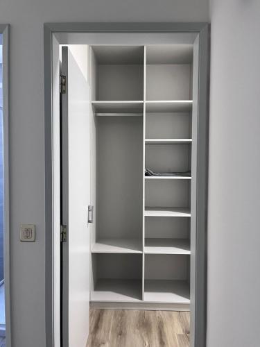 a closet with white shelves in a room at CASAS DONA EMILIA in Vieira de Leiria