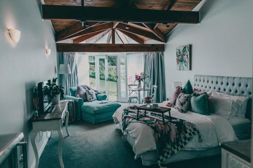 a bedroom with a bed and a couch and a table at Araluen Boutique Accommodation in Yarra Glen