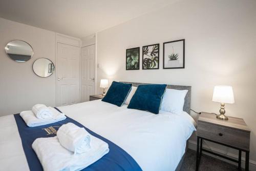 sypialnia z dużym białym łóżkiem z niebieskimi poduszkami w obiekcie Marykirk House 3 Double Bedrooms Workstays UK w mieście Thornaby on Tees