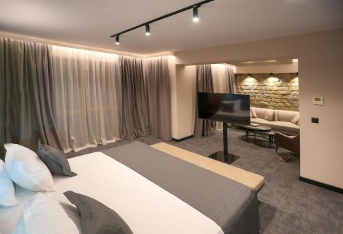 a hotel room with a bed and a flat screen tv at Grand Hotel Therme in Banya