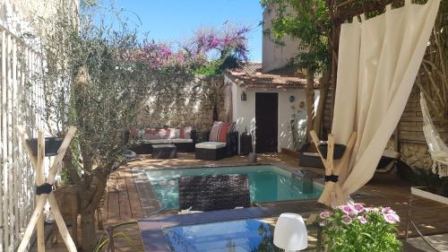 une cour arrière avec une piscine et une maison dans l'établissement La Demeure du Pressoir, à Cuxac-dʼAude