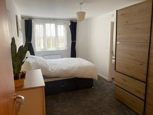 a bedroom with a bed and a large window at Lovely 2nd floor 2 bed flat sleeps 4 in Doncaster