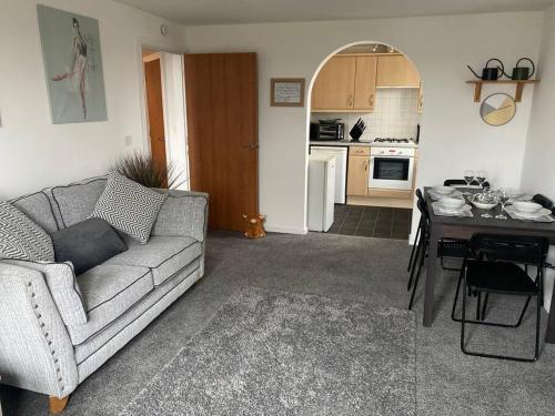 ein Wohnzimmer mit einem Sofa und einem Tisch in der Unterkunft Lovely 2nd floor 2 bed flat sleeps 4 in Doncaster