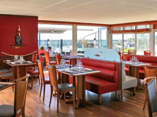 - une salle à manger avec des tables, des chaises et des fenêtres dans l'établissement ibis Granville Port De Plaisance, à Granville