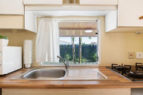 uma cozinha com um lavatório e uma janela em Villa Triana em Chiclana de la Frontera