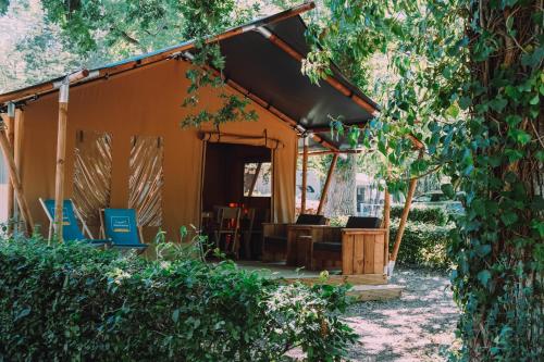 une tente orange avec une table et des chaises en bois dans l'établissement Camping de la Forêt Seasonova, à Sillé-le-Guillaume