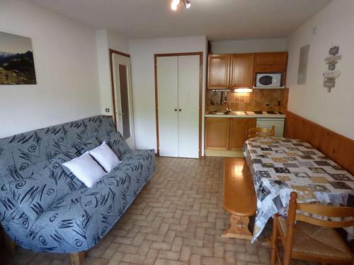 un salon avec un canapé et une cuisine dans l'établissement Appartement skis aux pieds, cosy 2 pièces, terrasse Sud/Est, 1er étage, idéal pour 4 personnes - FR-1-458-131, au Grand-Bornand