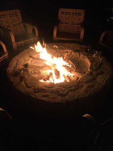 a fire pit in the dark with two chairs around it at Tanirt ecolodge in Siwa